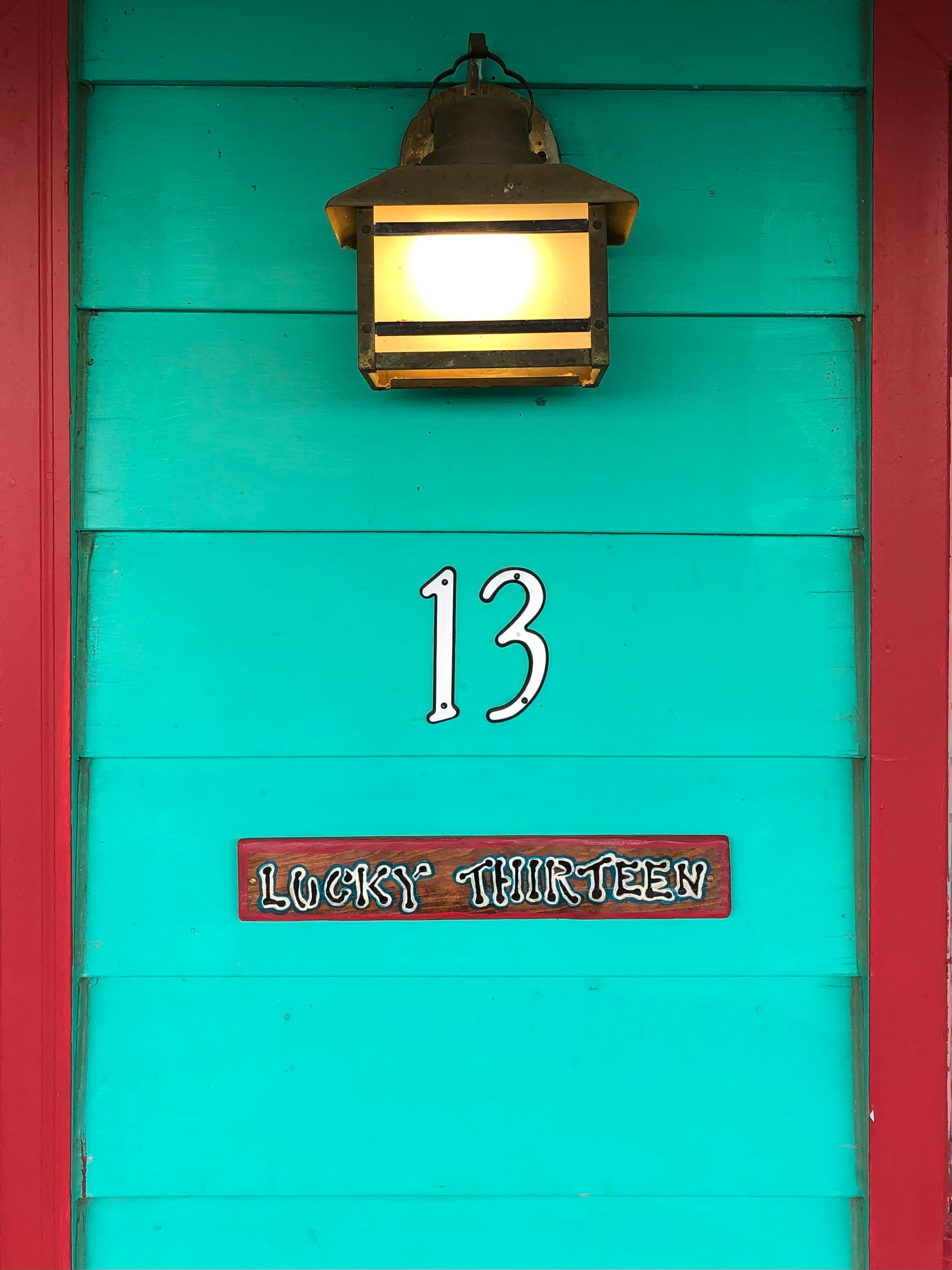 A turquoise door features the number 13 and a sign reading "Lucky Thirteen."