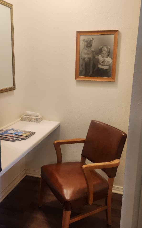 hotel vanity nook with chair and wall mirror and picture on the wall