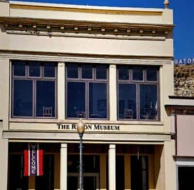 The exterior of The Raton Museum featuring large windows and a welcoming entrance.